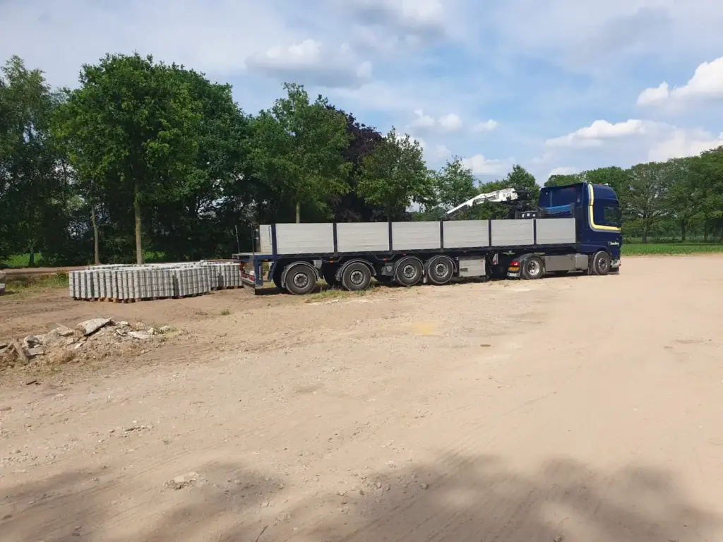 Een foto van een vrachtwagen van Knufing Transport, waar stenen bestrating werd getransporteerd.