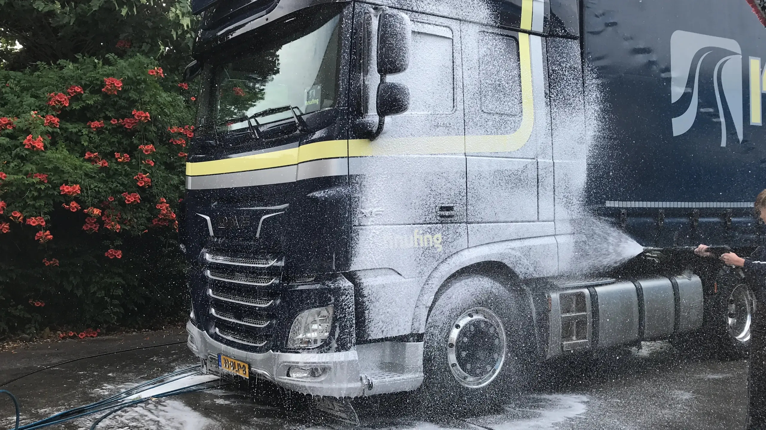Vrachtwagen van Knufing wordt gewassen door de wasploeg